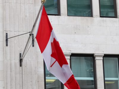 33147244_canada-flag-at-a-flagpole-moving-slowly-in-the-wind-against-the